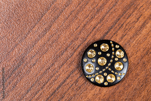 Black buttons with rhinestones on the wooden background