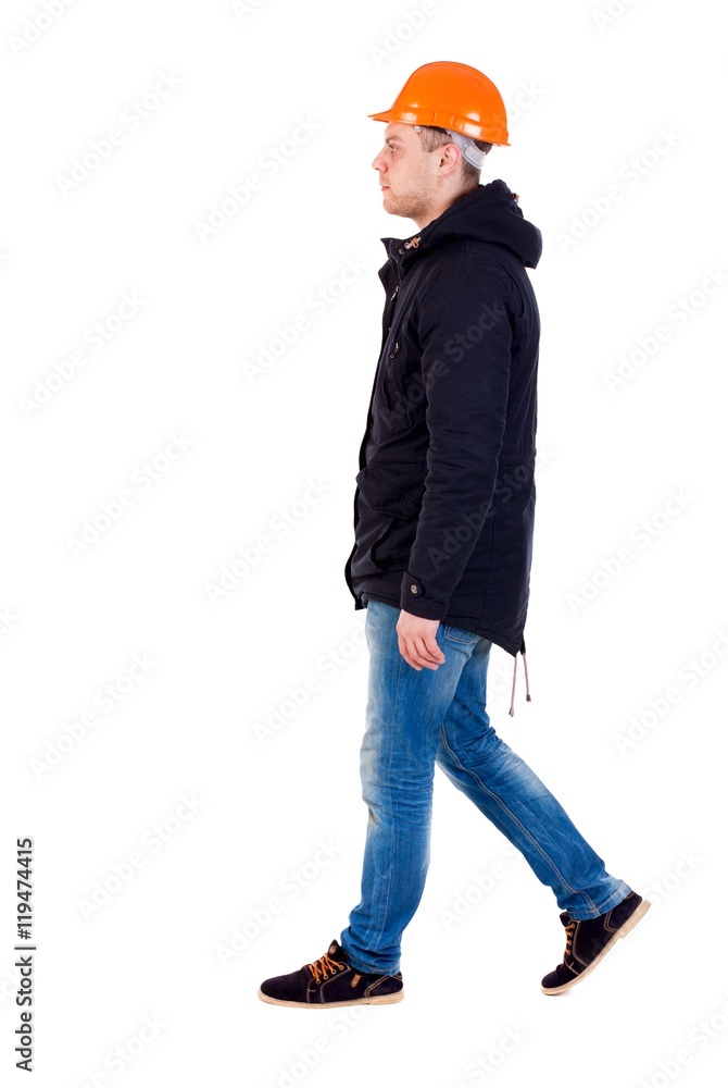 Back view of walking engineer in helmet. Isolated over white background. Engineer in warm clothes right away. Back view of walking engineer in helmet. Isolated over white background. Engineer in warm clothes right away.
