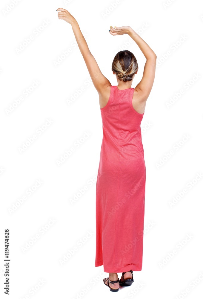 back view of dancing young beautiful woman. girl watching. R slender woman in a long red is raising his arms up. back view of dancing young beautiful woman. girl watching. R slender woman in a long red is raising his arms up.