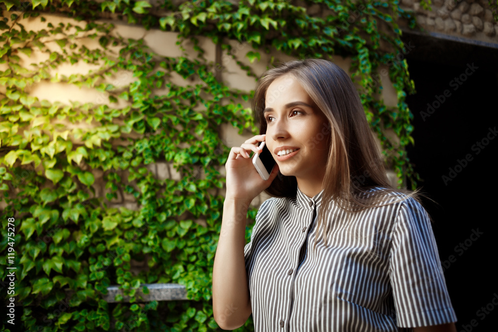Young beautiful cheerful girl walking around city, speaking on phone. Young beautiful cheerful girl walking around city, speaking on phone.