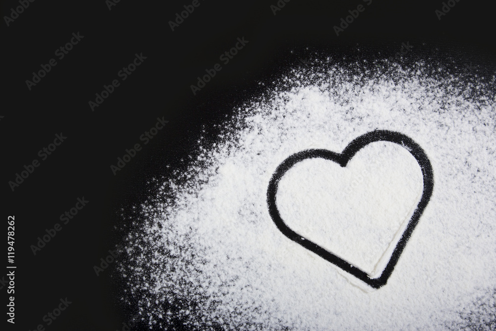 Flour and heart symbol. Flour on a black background. Flour and heart symbol. Flour on a black background.