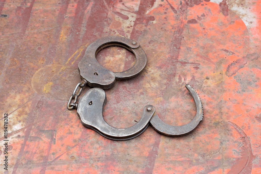 Old handcuffs on the table. Old rusty metal Old handcuffs on the table. Old rusty metal