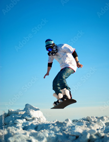 Snowboarder making jump against the clear blue sky