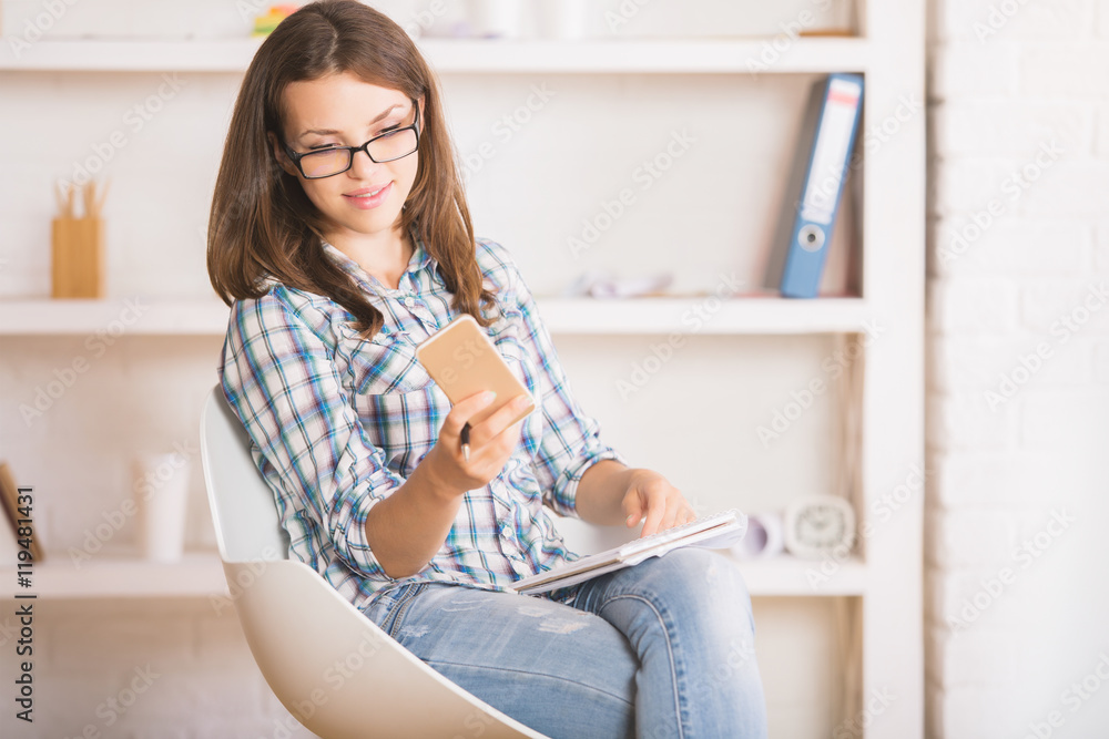 Pretty woman with notepad using cellphone Pretty woman with notepad using cellphone