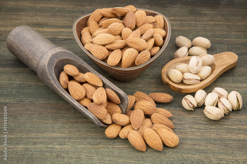Group of nuts on wooden table. Almonds, pistachios, macadamia and pecan nut Group of nuts on wooden table. Almonds, pistachios, macadamia and pecan nut