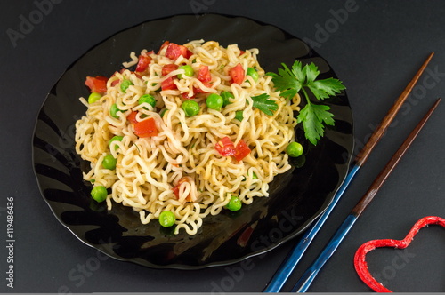 noodles with tomato and peas in a bowl
