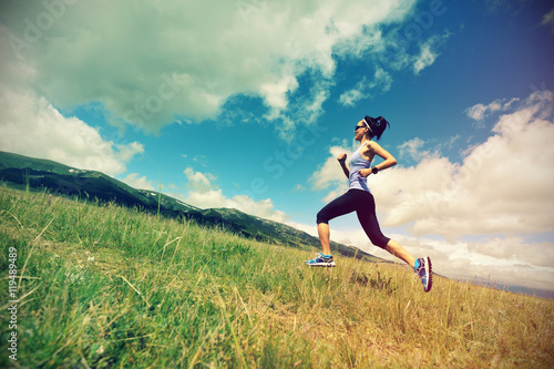 healthy lifestyle young fitness woman runner running on beautiful trail in grassland