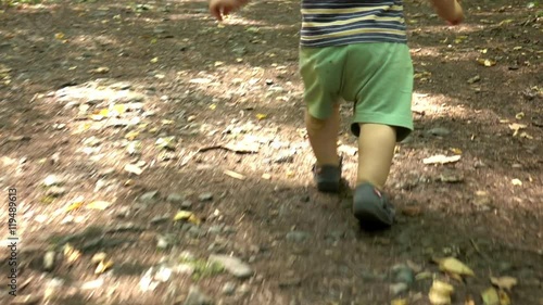 Baby is running at the forest path
