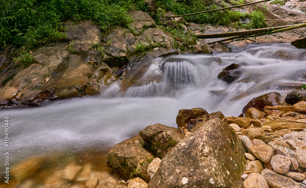 Water flows over rocks in a little waterfall. Water flows over rocks in a little waterfall.