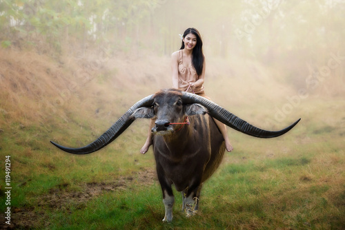 beautiful Asian girl riding long horn buffalo