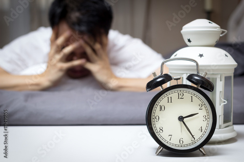 asian man in bed suffering insomnia and sleep disorder thinking about his problem at night photo
