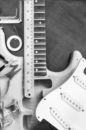 electric guitar on wood in repair & luthier workshop, fixing & musical instrument repairing concept, bw filter photo