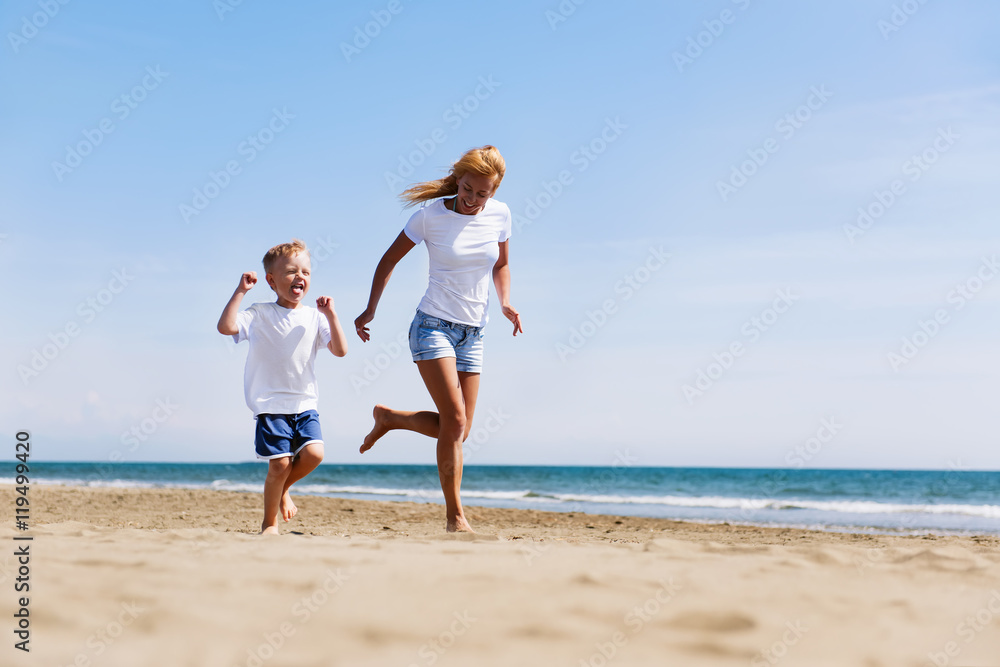 Shot of a young mother with her son running on the beach