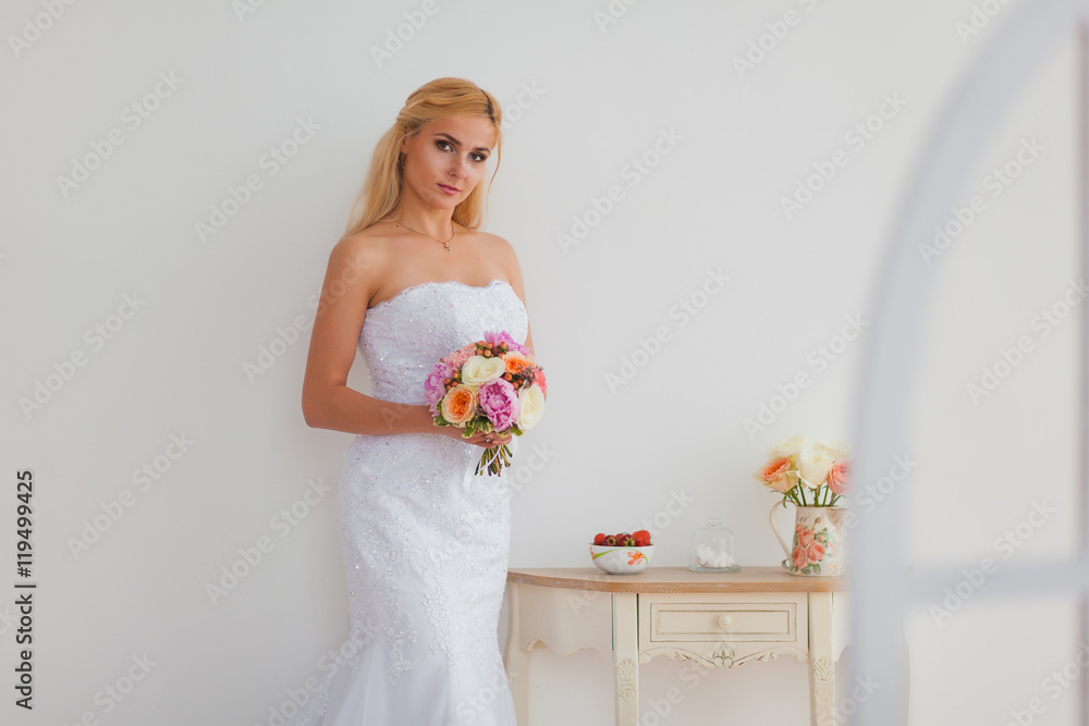Portrait of a beautiful blonde bride with bouquet in an interior light, wedding concept Portrait of a beautiful blonde bride with bouquet in an interior light, wedding concept