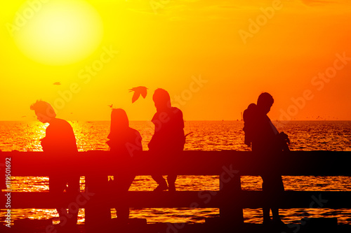 silhouette shadow group of teen friendship at sea coast in sunny dusk summer hot day.