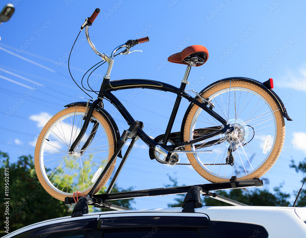 Fototapeta premium Bike transportation - bike on the roof of a car