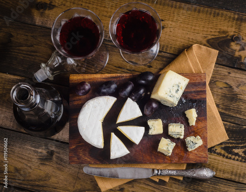 Cheese plate with grape and wine on wood