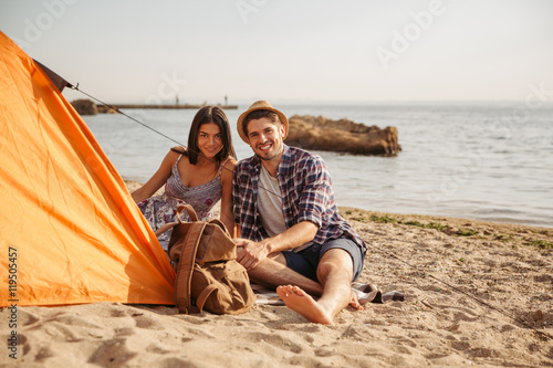 Happy young couple having fun camping at the beach