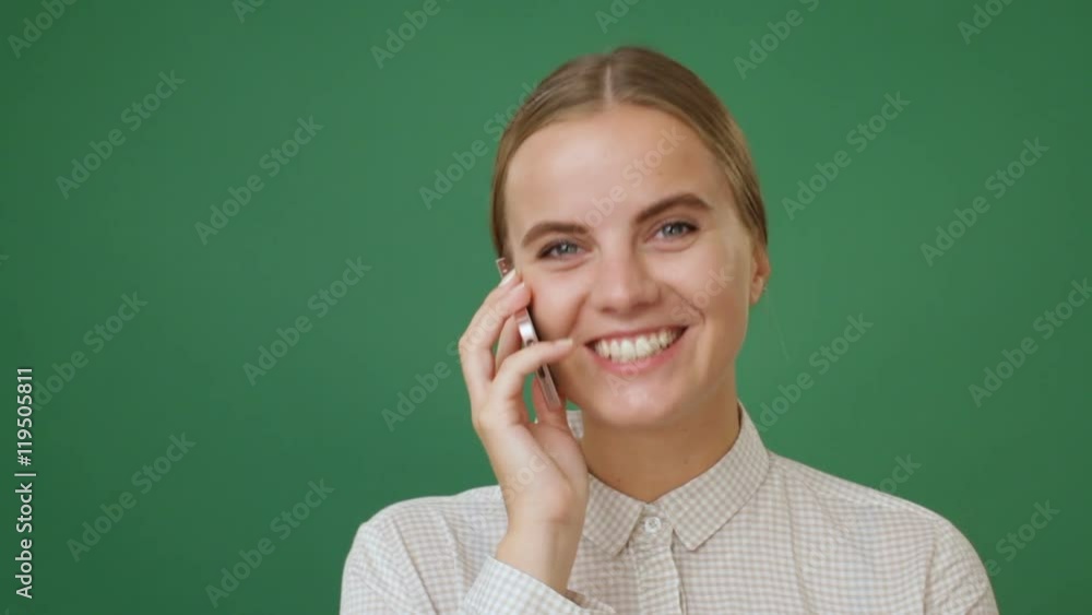 Young woman talking on the phone and smiling, green screen background Young woman talking on the phone and smiling, green screen background