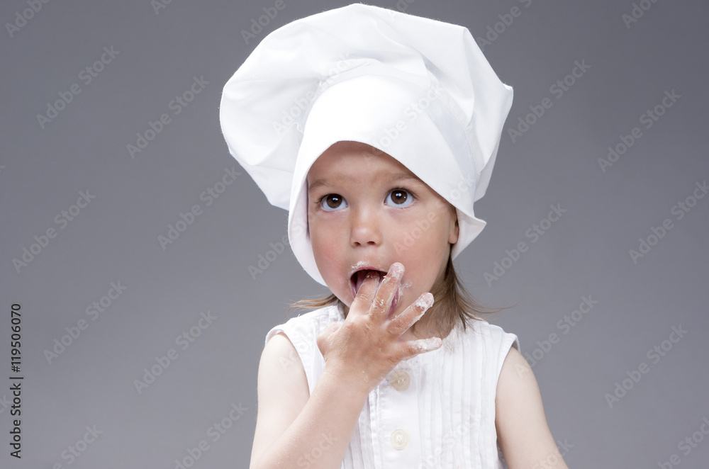 Funny Lovely Cute Caucasian Girl Posing as Cook. Against Gray Background Funny Lovely Cute Caucasian Girl Posing as Cook. Against Gray Background