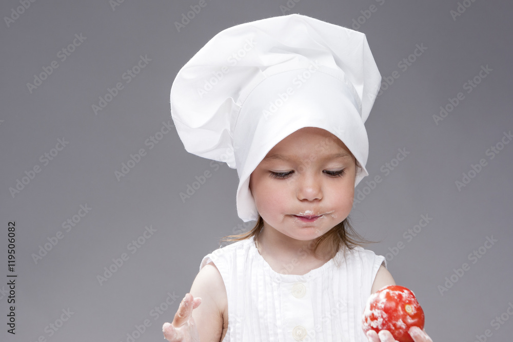 Cooking Concepts and Ideas. Portrait of Lovely Cute Caucasian Girl Posing as Cook in Cooking Hat. Against Gray. Horizontal Image Cooking Concepts and Ideas. Portrait of Lovely Cute Caucasian Girl Posing as Cook in Cooking Hat. Against Gray. Horizontal Image