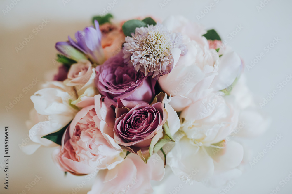 Wedding bridal bouquet of flowers and greenery is on a white table Wedding bridal bouquet of flowers and greenery is on a white table