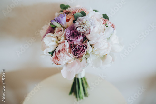 Wedding bridal bouquet of flowers and greenery is on a white table
