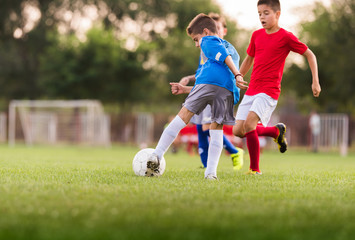 Boys playing football soccer game on sports field