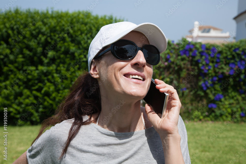 portrait of brunette woman with white cap, black sunglasses and grey shirt smiling and listening to mobile phone smartphone with green plants garden background
portrait of brunette woman with white cap, black sunglasses and grey shirt smiling and listening to mobile phone smartphone with green plants garden background