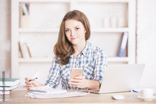 Young woman using smartphone at workplace