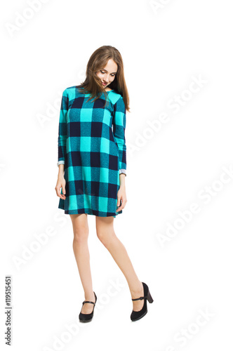 Young cute girl in a checkered dress isolated on white background.