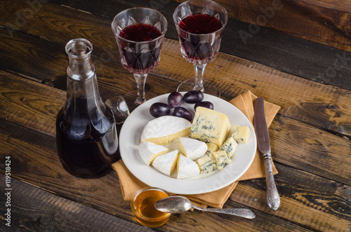 Cheese plate with grape and wine on wood photo