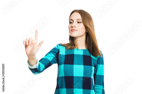 Young cute girl in a checkered dress holding a finger in the air isolated on white background.