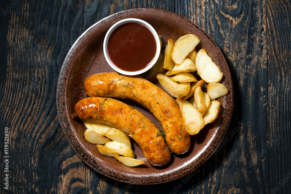 fried pork sausages with potatoes and ketchup, top view fried pork sausages with potatoes and ketchup, top view