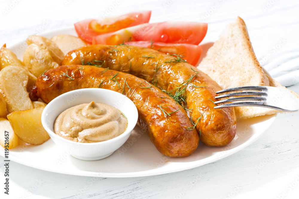 fried pork sausages with potatoes and mustard, closeup fried pork sausages with potatoes and mustard, closeup