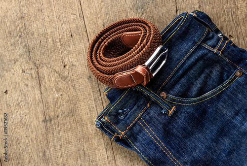 Jeans and belt on a wooden floor