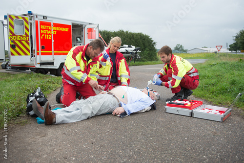 Rettungsdienst und Notarzt versorgen einen schwer kranken Mann photo