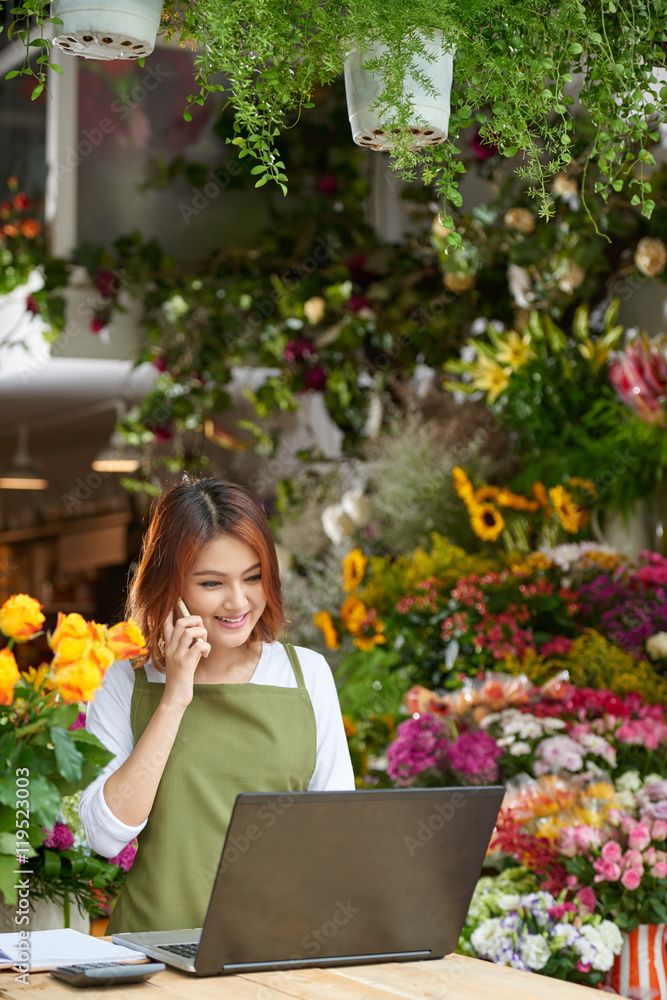 Florist accepting order of client on the phone Florist accepting order of client on the phone
