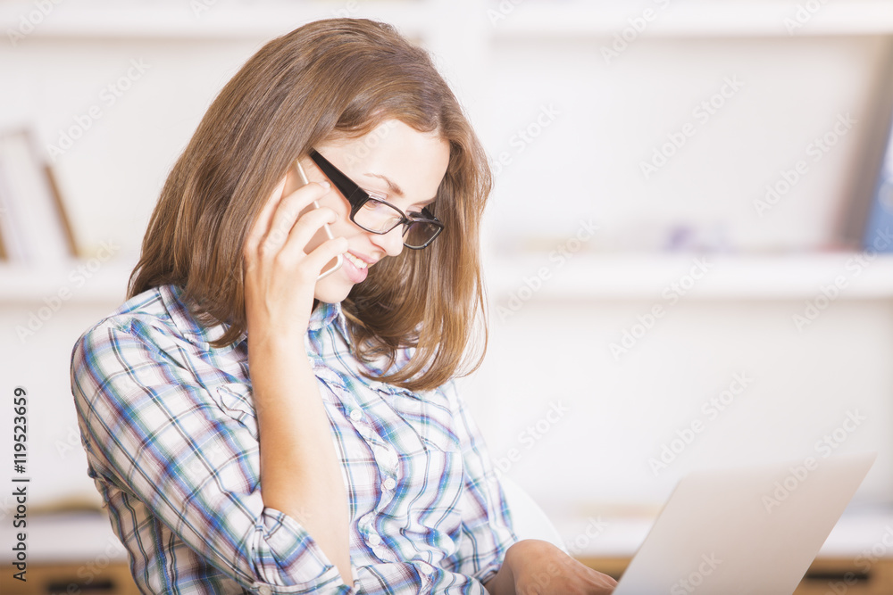 Smiling woman on phone using laptop Smiling woman on phone using laptop