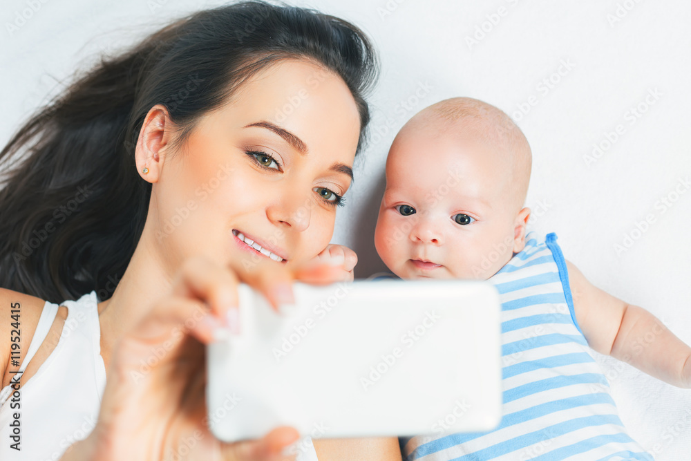 Funny baby and mother make selfie on mobile phone Funny baby and mother make selfie on mobile phone
