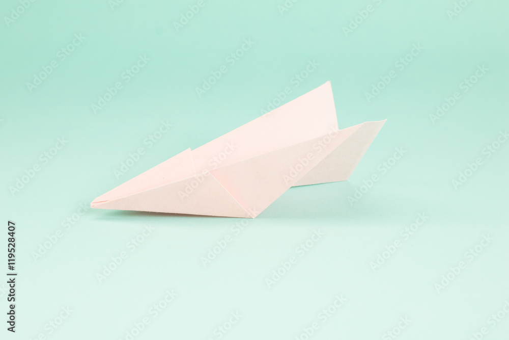 Naklejka premium Fold rocket paper on green background.