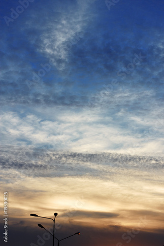 Colorful clouds and lamppost. Sky, lit by setting sun. Natural background. Texture of clouds.