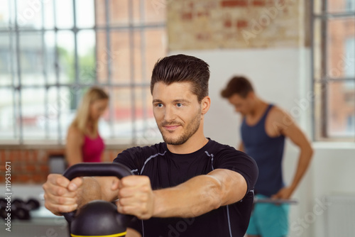 bodybuilder trainiert mit kettleball im studio