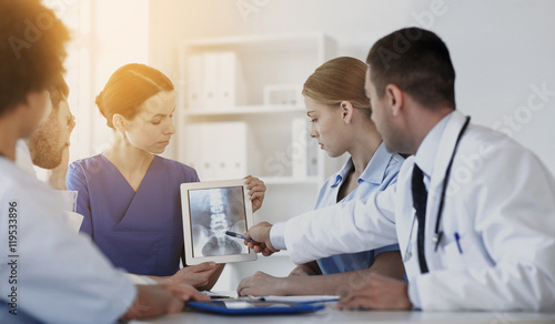 group of doctors with x-ray on tablet pc at clinic