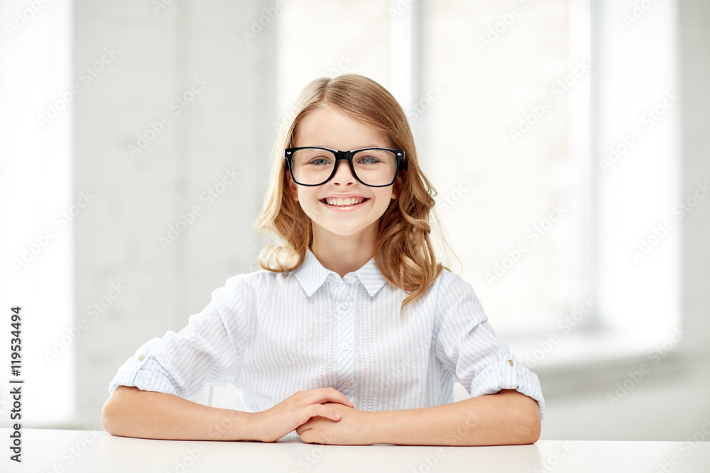 happy school girl in glasses sitting at table happy school girl in glasses sitting at table