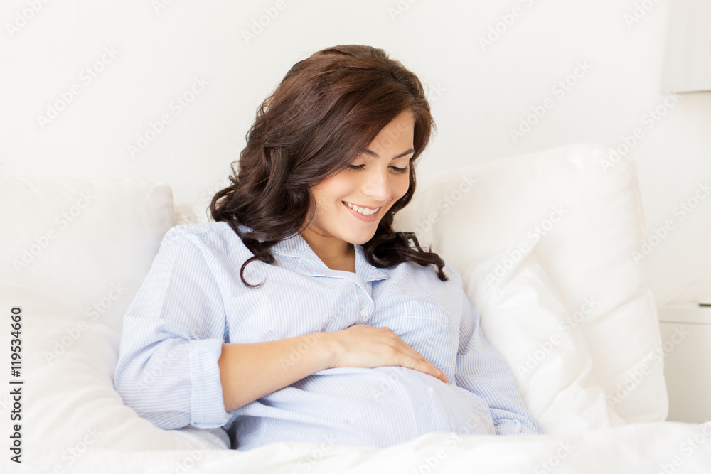 happy pregnant woman lying on bed at home happy pregnant woman lying on bed at home