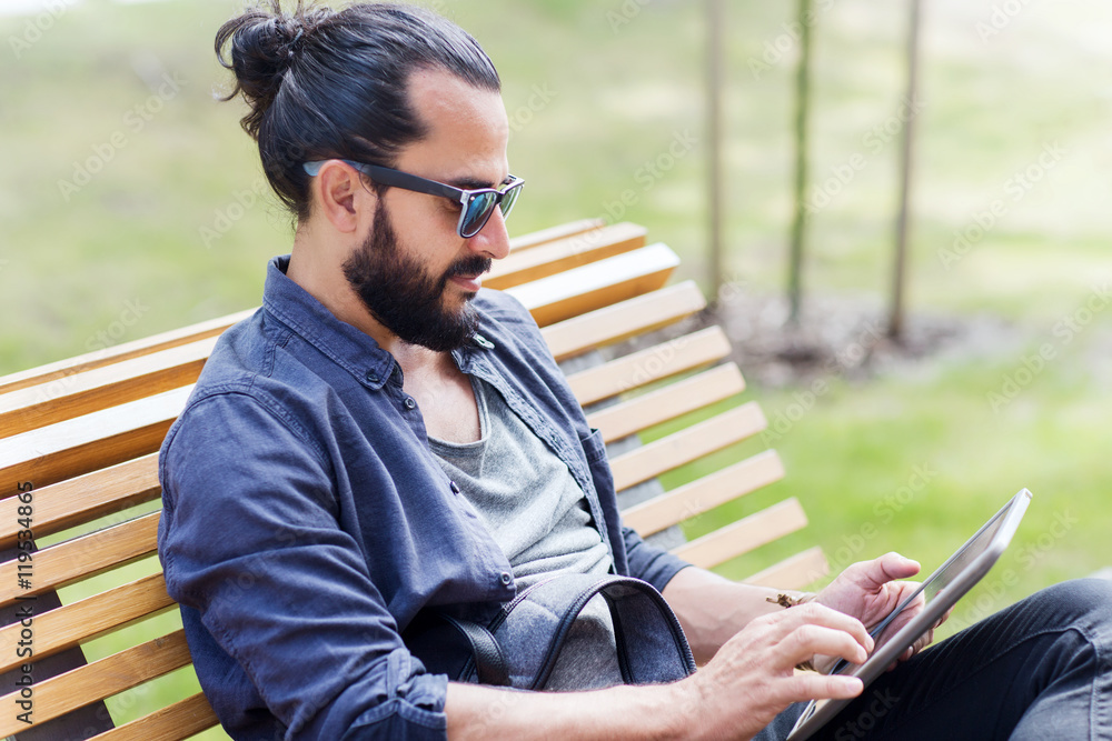 man with tablet pc sitting on city street bench man with tablet pc sitting on city street bench