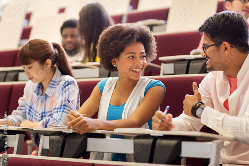 Valokuva group of students with notebooks in lecture hall