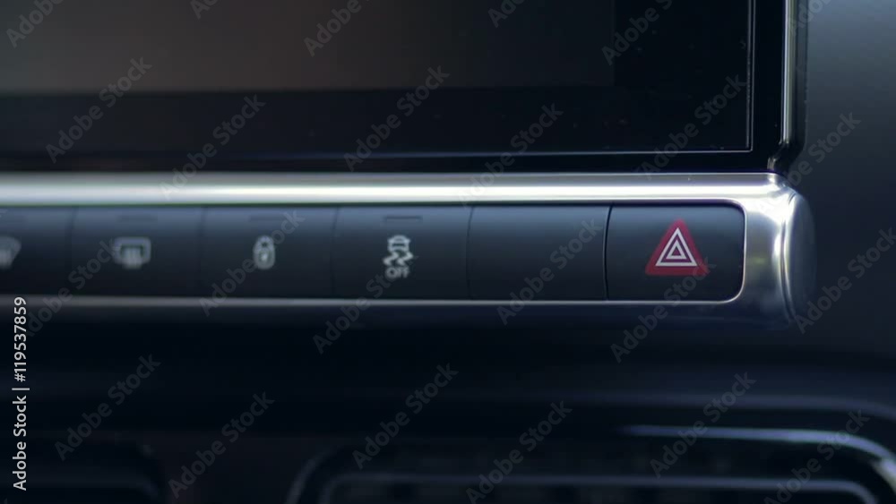Woman pressing emergency button on car dashboard Woman pressing emergency button on car dashboard