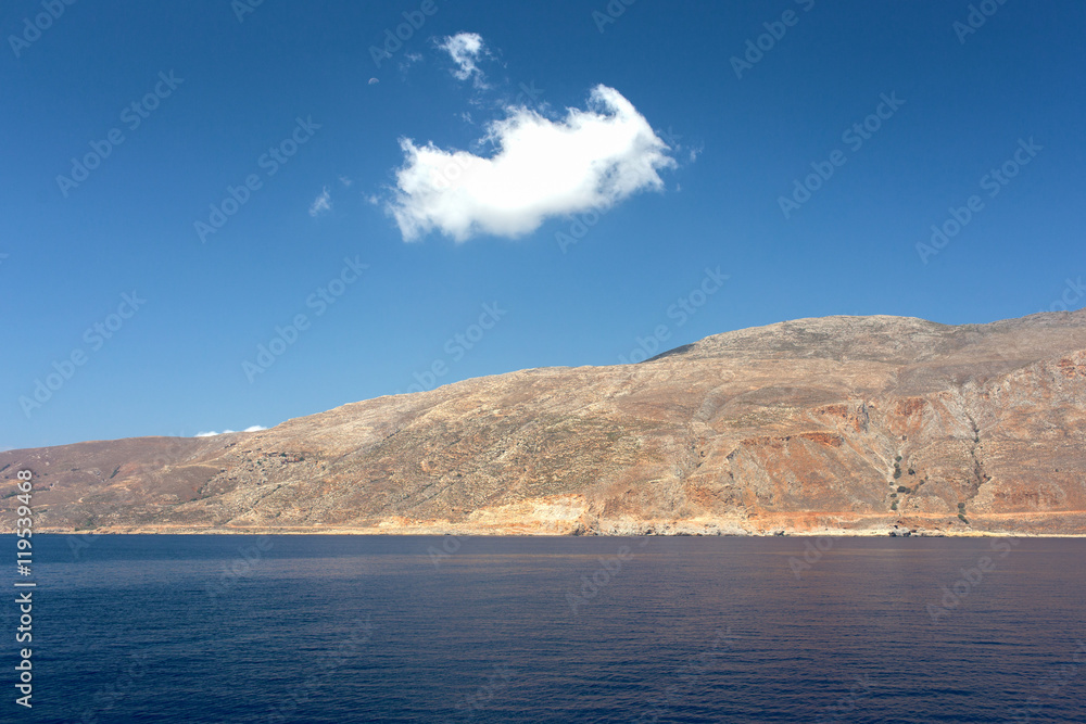 Little cloud on a large mountain in a tranquil and beautiful sea